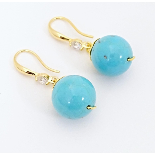 654 - A pair of gilt metal drop earrings set with turquoise coloured beads with white stone detail. Approx... 