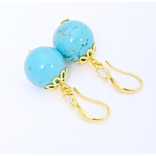 654 - A pair of gilt metal drop earrings set with turquoise coloured beads with white stone detail. Approx... 