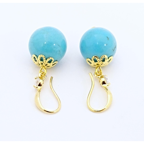 654 - A pair of gilt metal drop earrings set with turquoise coloured beads with white stone detail. Approx... 