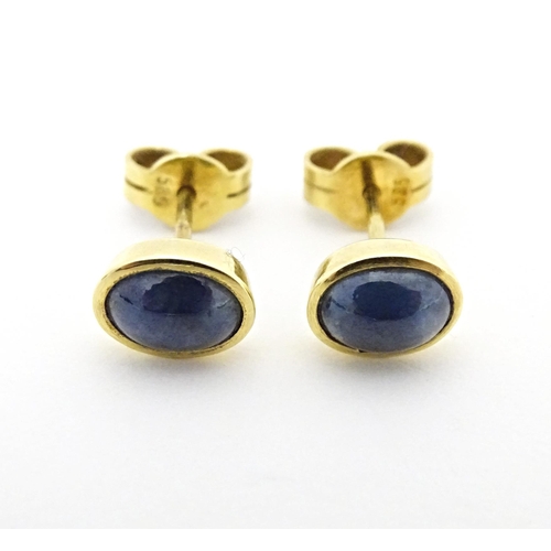 651 - A pair of 14ct gold stud earrings set with sapphire cabochon. Approx. 1/4