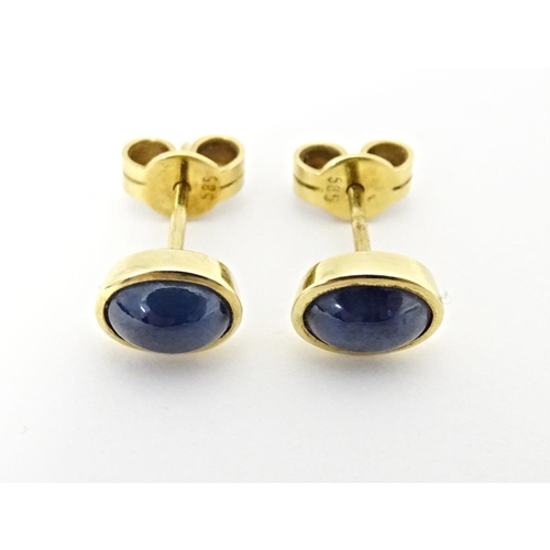 651 - A pair of 14ct gold stud earrings set with sapphire cabochon. Approx. 1/4