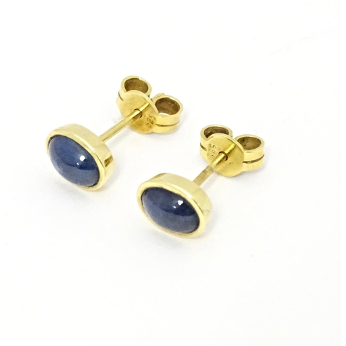 651 - A pair of 14ct gold stud earrings set with sapphire cabochon. Approx. 1/4