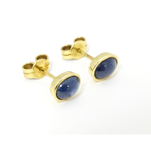 651 - A pair of 14ct gold stud earrings set with sapphire cabochon. Approx. 1/4