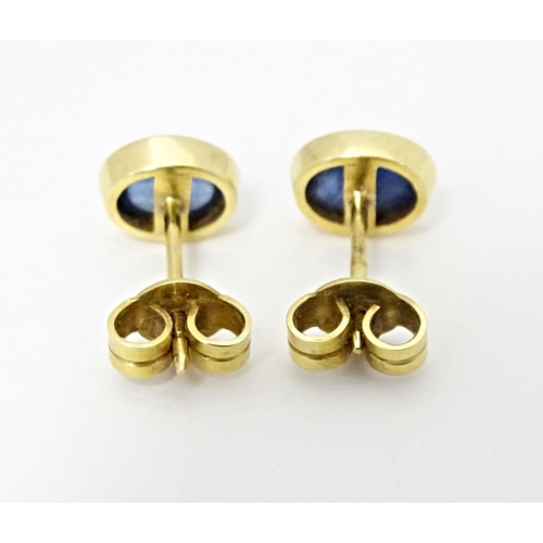 651 - A pair of 14ct gold stud earrings set with sapphire cabochon. Approx. 1/4