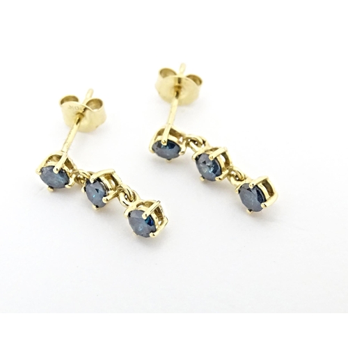 658 - A pair of 9ct gold drop earrings set with blue coloured diamonds. Approx. 1/2