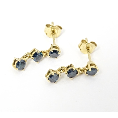 658 - A pair of 9ct gold drop earrings set with blue coloured diamonds. Approx. 1/2