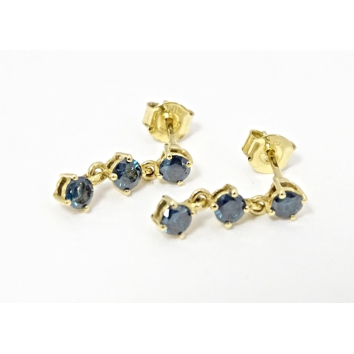 658 - A pair of 9ct gold drop earrings set with blue coloured diamonds. Approx. 1/2