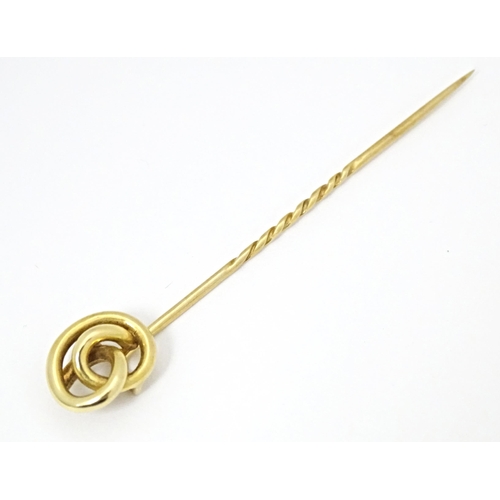 660 - A yellow metal stick pin with knot detail. Approx. 3