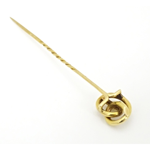 660 - A yellow metal stick pin with knot detail. Approx. 3