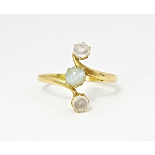 578 - A 22ct gold ring set with central cats eye moonstone and two moonstone cabochons. Ring size approx. ... 