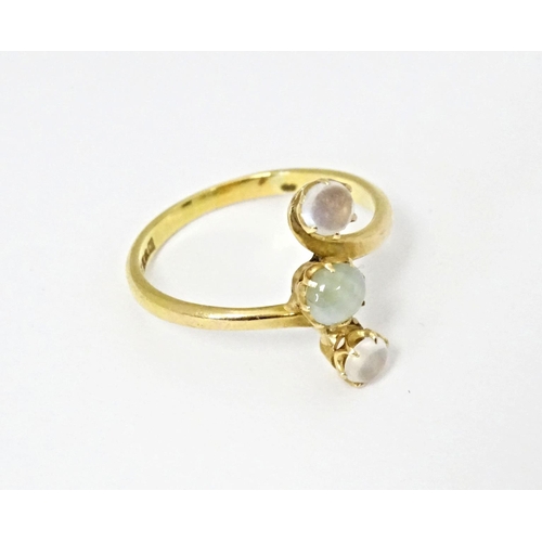 578 - A 22ct gold ring set with central cats eye moonstone and two moonstone cabochons. Ring size approx. ... 