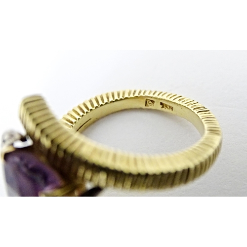 579 - An 18ct gold cocktail ring set with central amethyst flanked by diamonds. Ring size approx. O