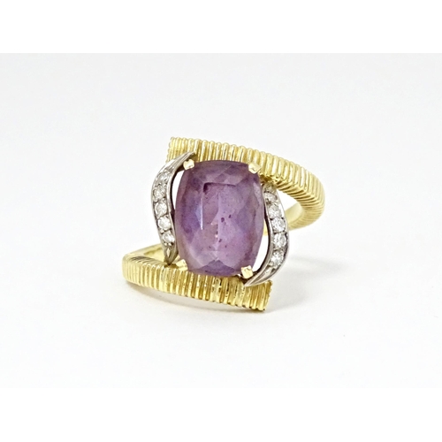 579 - An 18ct gold cocktail ring set with central amethyst flanked by diamonds. Ring size approx. O