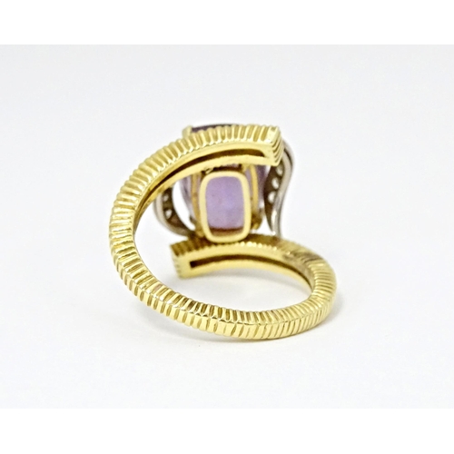 579 - An 18ct gold cocktail ring set with central amethyst flanked by diamonds. Ring size approx. O