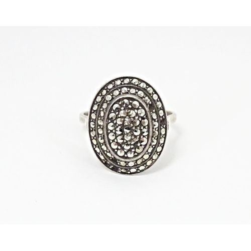 580 - A white metal ring set with a profusion of marcasite in an Art Deco setting. Ring size approx. Q