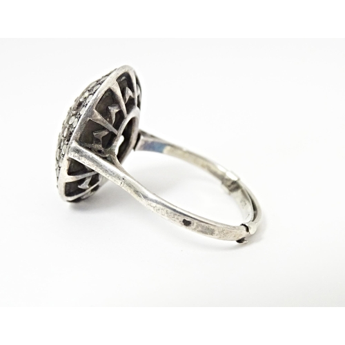 580 - A white metal ring set with a profusion of marcasite in an Art Deco setting. Ring size approx. Q