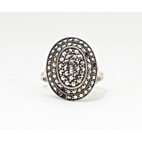 580 - A white metal ring set with a profusion of marcasite in an Art Deco setting. Ring size approx. Q