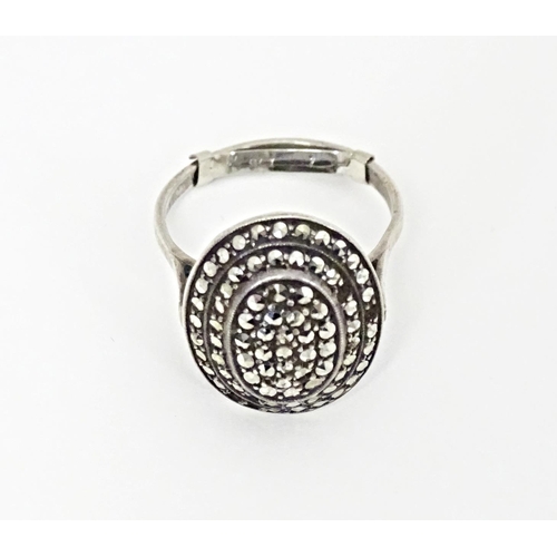 580 - A white metal ring set with a profusion of marcasite in an Art Deco setting. Ring size approx. Q