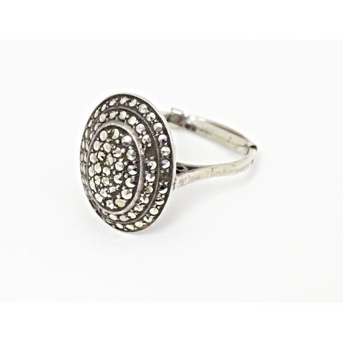 580 - A white metal ring set with a profusion of marcasite in an Art Deco setting. Ring size approx. Q