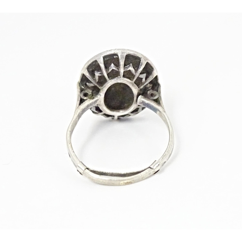 580 - A white metal ring set with a profusion of marcasite in an Art Deco setting. Ring size approx. Q