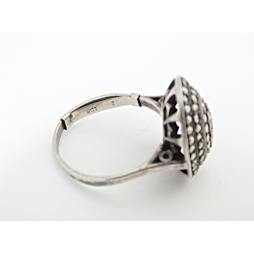 580 - A white metal ring set with a profusion of marcasite in an Art Deco setting. Ring size approx. Q