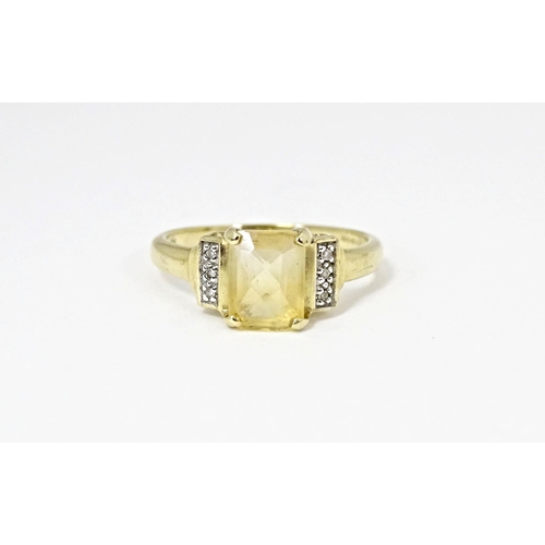 581 - A 9ct gold ring set with central citrine flanked by diamonds. Ring size approx. N