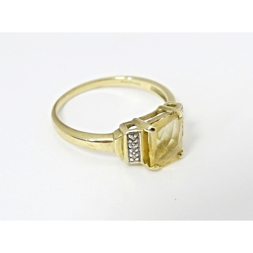 581 - A 9ct gold ring set with central citrine flanked by diamonds. Ring size approx. N