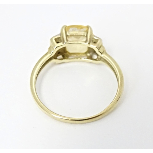 581 - A 9ct gold ring set with central citrine flanked by diamonds. Ring size approx. N