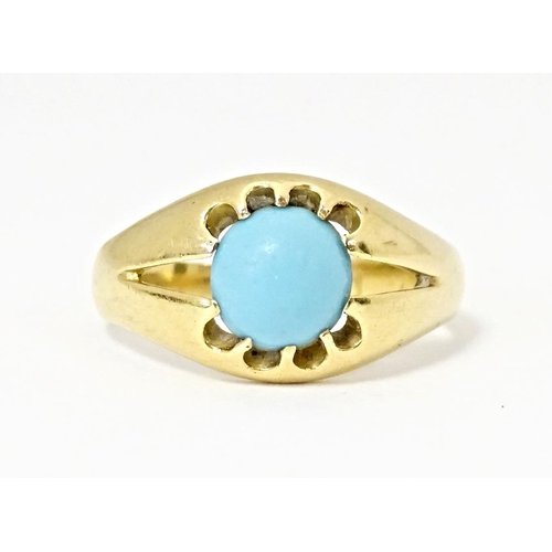 587 - A yellow metal ring set with central turquoise cabochon. Ring size approx. L