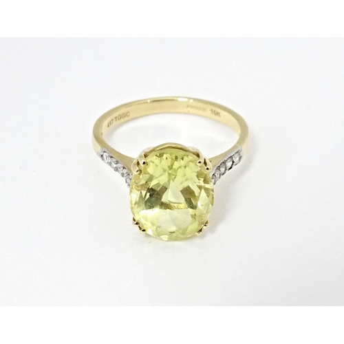 589 - A 9ct gold ring set with central citron feldspar flanked by ratanakiri zircons. Ring size approx. N