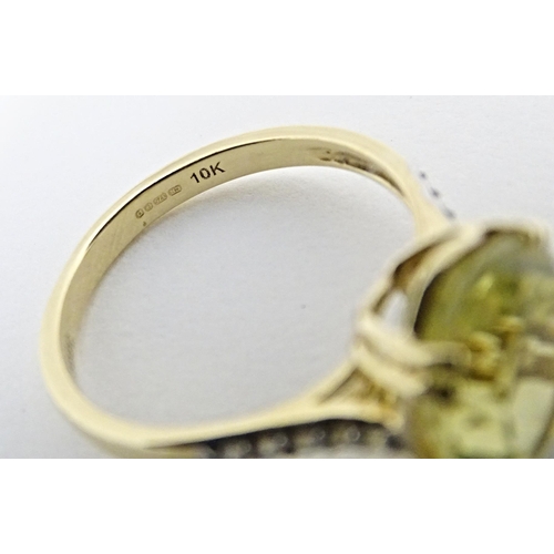 589 - A 9ct gold ring set with central citron feldspar flanked by ratanakiri zircons. Ring size approx. N