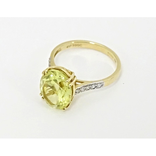 589 - A 9ct gold ring set with central citron feldspar flanked by ratanakiri zircons. Ring size approx. N