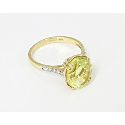 589 - A 9ct gold ring set with central citron feldspar flanked by ratanakiri zircons. Ring size approx. N