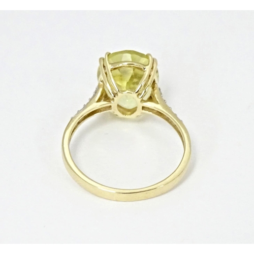 589 - A 9ct gold ring set with central citron feldspar flanked by ratanakiri zircons. Ring size approx. N