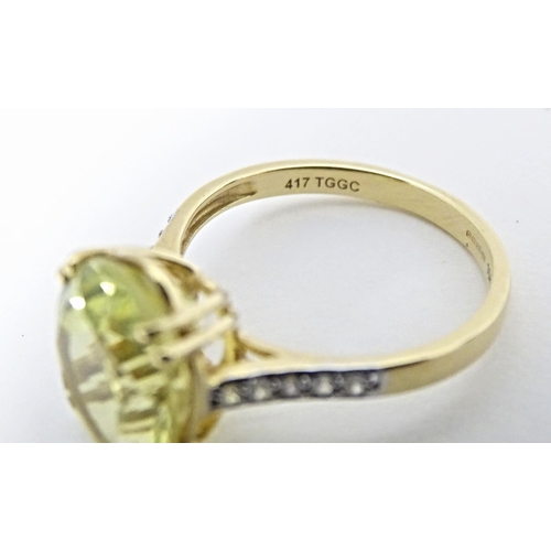 589 - A 9ct gold ring set with central citron feldspar flanked by ratanakiri zircons. Ring size approx. N