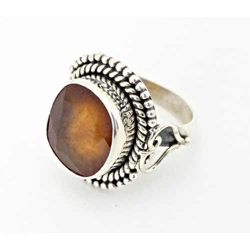 591 - A white metal ring set with central hessonite garnet. Ring size approx. N