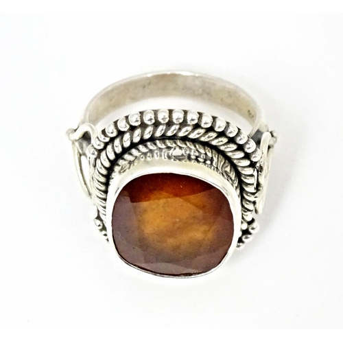 591 - A white metal ring set with central hessonite garnet. Ring size approx. N