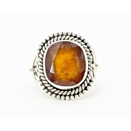 591 - A white metal ring set with central hessonite garnet. Ring size approx. N