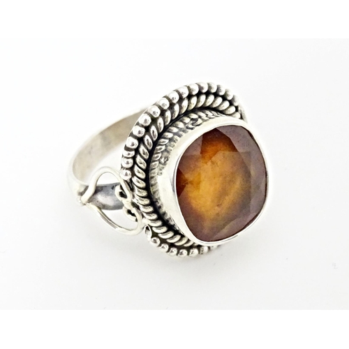 591 - A white metal ring set with central hessonite garnet. Ring size approx. N