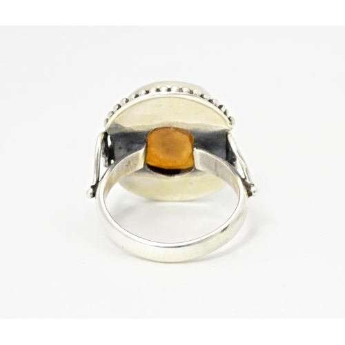 591 - A white metal ring set with central hessonite garnet. Ring size approx. N