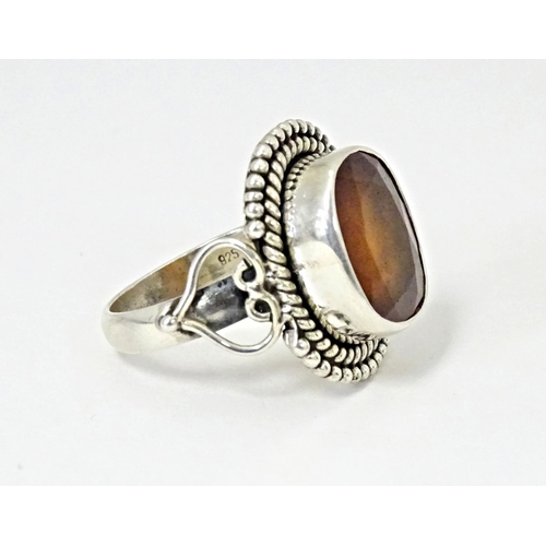 591 - A white metal ring set with central hessonite garnet. Ring size approx. N