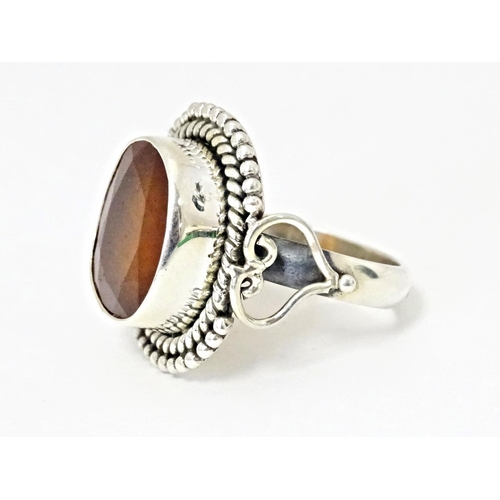 591 - A white metal ring set with central hessonite garnet. Ring size approx. N