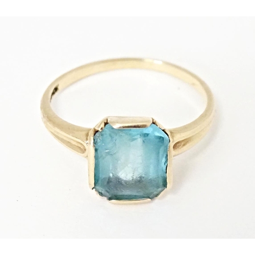 598 - A Continental Art Deco style 10k gold ring set with central blue stone. Ring size approx. N 1/2