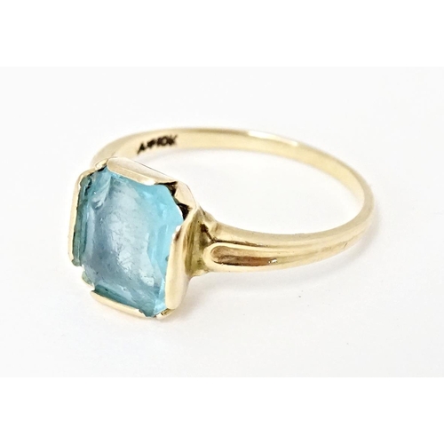 598 - A Continental Art Deco style 10k gold ring set with central blue stone. Ring size approx. N 1/2