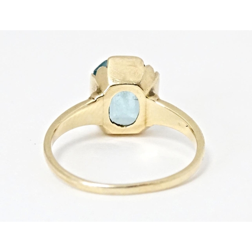 598 - A Continental Art Deco style 10k gold ring set with central blue stone. Ring size approx. N 1/2