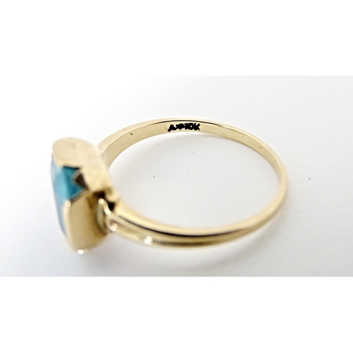 598 - A Continental Art Deco style 10k gold ring set with central blue stone. Ring size approx. N 1/2