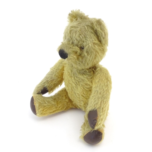 825 - Toy: A 20thC mohair teddy bear with stitched nose and mouth, pad paws and articulated limbs, a clock... 