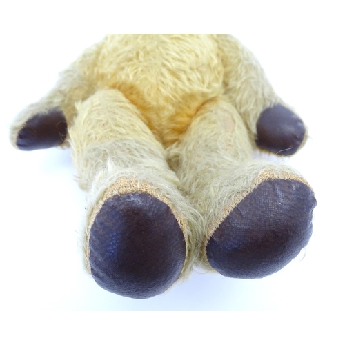 825 - Toy: A 20thC mohair teddy bear with stitched nose and mouth, pad paws and articulated limbs, a clock... 