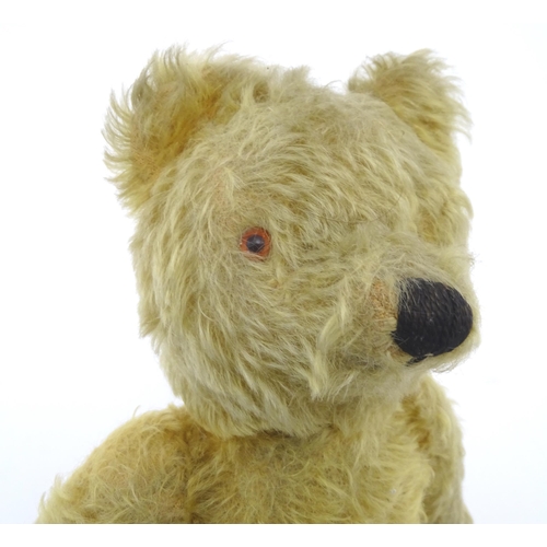 825 - Toy: A 20thC mohair teddy bear with stitched nose and mouth, pad paws and articulated limbs, a clock... 