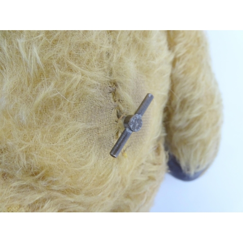 825 - Toy: A 20thC mohair teddy bear with stitched nose and mouth, pad paws and articulated limbs, a clock... 